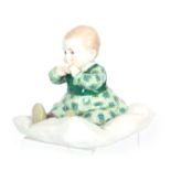 AN EARLY 20th CENTURY MEISSEN FIGURE OF A BABY SEATED ON A CUSHION modelled by Konrad Hentschel