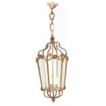 A REGENCY HEXAGONAL SHAPED ROCOCO STYLE GILT BRASS HANGING LANTERN with shaped bevelled glasses