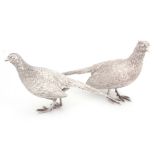 A STYLISH PAIR OF STERLING SILVER SCULPTURES modelled as a standing cock and hen pheasant 35cm long.