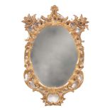 AN EARLY GEORGE III OVAL CARVED GILT GESSO HANGING MIRROR with leaf moulded pierced frame having C