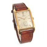 A GENTLEMAN'S 18CT GOLD OMEGA WRIST WATCH on a brown leather strap, the rectangular case enclosing a
