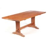 A 20TH CENTURY FOXMAN AZED OAK REFECTORY DINING TABLE with plank top above shaped end supports
