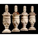 A SET OF FOUR REGENCY RE-CONSTITUTED STONE LIDDED URNS with swag work decoration and ring turned
