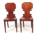 A PAIR OF REGENCY MAHOGANY HALL CHAIRS with angled octagonal-shaped backs, above plank seats and