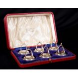 AN EDWARDIAN CASED SET OF SIX SILVER MENU HOLDERS FORMED AS RIDING STIRRUPS the circular bases