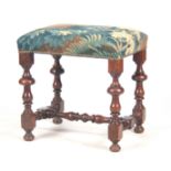 A LATE 17TH CENTURY WILLIAM AND MARY WALNUT STOOL with turned legs joined by a H stretcher; with