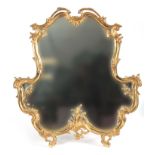 A 19TH CENTURY FRENCH ROCOCO STYLE ORMOLU EASLE MIRROR with swept leaf work shaped frame and brass