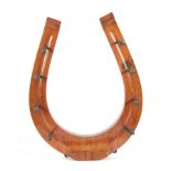 A LATE 19TH CENTURY WALNUT HORSESHOE SHAPED HANGING COAT HOOK with square nail pegs 47.5cm high 38cm