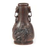 A CHINESE QING DYNASTY CARVED RHINOCEROS HORN SNUFF BOTTLE having masked hoop handles and mythical
