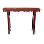 A 19TH CENTURY CHINESE HARDWOOD ALTAR TABLE with panelled top above an open pierced frieze, standing