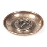 AN EDWARD VII CIRCULAR SILVER PIN TRAY the raised centre set with a frog fitted green jewelled