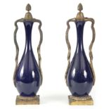 A PAIR OF 19TH CENTURY FRENCH ORMOLU MOUNTED PORCELAIN URNS having purple glazed bulbous bodies
