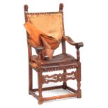 A 17TH CENTURY SPANISH WALNUT ARMCHAIR with carved lions head frame, leather upholstery and shaped