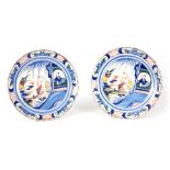 A PAIR OF EARLY 18TH CENTURY DELFT POLYCHROME PLATES decorated Oriental scenes with figures and