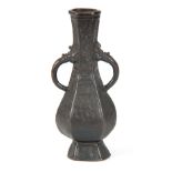 AN EARLY CHINESE BRONZE VASE of hexagonal bulbous panelled form with overall hatched decoration