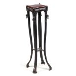 AN ART NOVEAU CAST IRON AND COPPER MOUNTED JARDINIERE STAND with mask head corners below a walnut