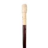 AN EARLY 20TH CENTURY JAPANESE WALKING CANE with an ivory handle formed as a clenched fist and