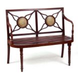 A REGENCY MAHOGANY HALL BENCH with slatted shaped seat, sweeping arms and pierced flower-shaped back