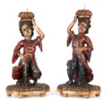 A PAIR OF 18TH CENTURY ITALIAN POLYCHROME FIGURAL PRICKET STICKS mounted on leaf carved bases;