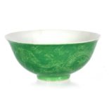 A CHINESE GREEN PORCELAIN FOOTED BOWL decorated with a dragon amongst clouds - signed with six-