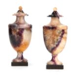 A GOOD PAIR OF 19TH CENTURY BLUE JOHN COVERED URNS the one piece bodies on square black slate