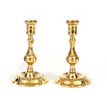 AN UNUSUAL PAIR OF MID 18TH CENTURY BRASS CANDLESTICKS with ringed and facetted bulbous stems on