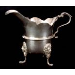 A GEORGE V .925 HALLMARKED IRISH SILVER CREAM JUG of helmet shape with scroll handle and girdled