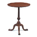 A GEORGE III FIGURED MAHOGANY OCCASIONAL TABLE with a pie-crust moulded one-piece top; on a tapering