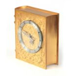 A MID 20TH CENTURY SWISS GILT BRASS NOVELTY MANTEL CLOCK formed as a book with curved spine and