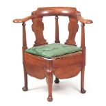 A GEORGE I WALNUT CORNER COMMODE CHAIR with raised back on a shaped bowed armrest supported by
