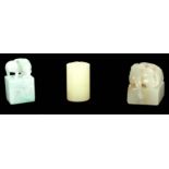 A COLLECTION OF THREE CHINESE GREEN JADE SEALS a cylindrical pale green seal with relief floral