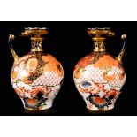 A PAIR OF ROYAL CROWN DERBY BULBOUS EWERS the slender leaf moulded necks and broad rims in gilt