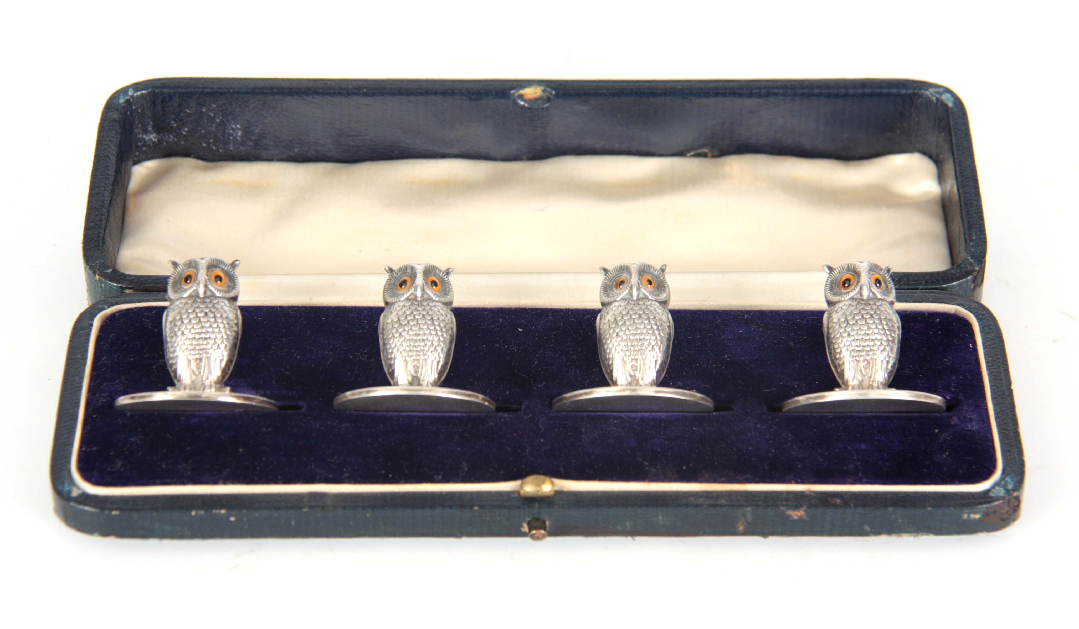 AN EDWARD VII CASED SET OF FOUR NOVELTY SILVER MENU HOLDERS modelled as owls, having amber set