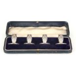 AN EDWARD VII CASED SET OF FOUR NOVELTY SILVER MENU HOLDERS modelled as owls, having amber set