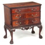 A 20TH CENTURY GEORGE II STYLE FLAME MAHOGANY IRISH COMMODE with carved moulded cross-banded top