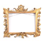 AN GEORGE III CARVED GILTWOOD FRAME with elaborate leafwork and floral decoration 72cm wide 66cm