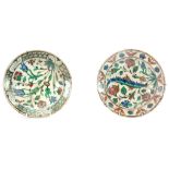 TWO 17th CENTURY IZNIK DISHES brightly decorated with flowerheads and leaf sprays 25.5cm diameter