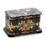 A 19TH CENTURY BLACK JAPANNED PAPIER MACHE TEA CADDY of shaped rectangular form with scrolling