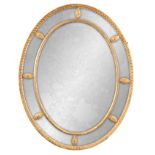 AN EARLY 19TH CENTURY OVAL GILT GESSO REGENCY HANGING MIRROR with applied rosettes and inner moulded