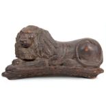 AN EARLY 17TH CENTURY CARVED PINE SCULPTURE OF A RECUMBENT LION 78cm wide 39cm high.