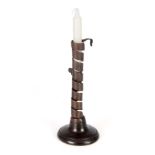 AN 18TH CENTURY SPIRAL STEM IRONWORK PIGTAIL CANDLESTICK with adjusting candle ejector and ringed