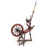A 19TH CENTURY FRUITWOOD SPINNING WHEEL the large wheel having ivory inlaid roundels and treddle