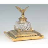 AN IMPRESSIVE LATE 19TH CENTURY BRASS INKWELL OF LARGE SIZE of square form, the moulded glass