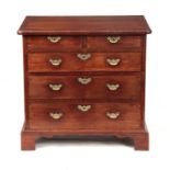 A GEORGE II WALNUT CHEST OF DRAWERS with cross-banded top above two short and three long graduated