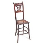 A 19TH CENTURY LATE REGENCY SIMULATED ROSEWOOD STAINED BEECH CHILD'S CORRECTION CHAIR with lyre-