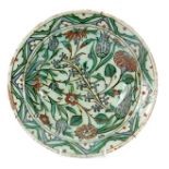 A 17th CENTURY IZNIK DISH brightly decorated with flower heads and leaf sprays 29cm diameter