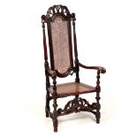 A WILLIAM AND MARY WALNUT BERGERE ARMCHAIR with shaped scroll carved cresting rail supported