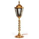 AN EARLY 20TH CENTURY BRASS TABLE LAMP formed as a lantern with hammered effect glass; mounted on