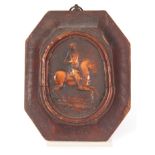 AN EARLY CARVED AMBER HANGING PLAQUE depicting a soldier on horseback, mounted in a moulded frame