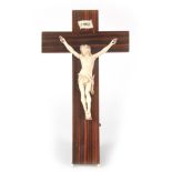 A LATE 19TH CENTURY CARVED IVORY CRUCIFIX mounted on a rosewood veneered cross 35cm high 25cm wide.